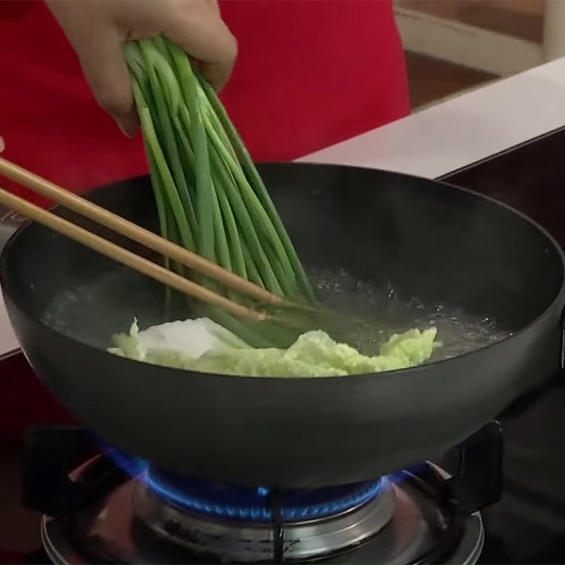 Sơ chế các loại rau củ như bắp và ngò rí để thêm vào món canh cải thảo cuộn thịt.