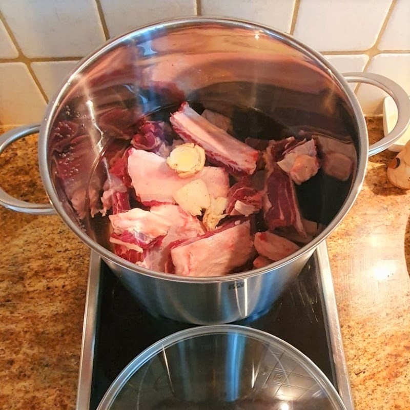 Vớt sườn bò ra khỏi nước chần để làm nguội và rửa sạch chuẩn bị nấu phở bò kho