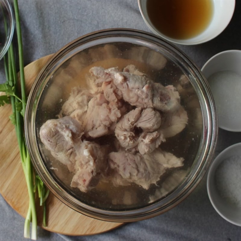 Rửa sạch sườn heo sau khi luộc sơ để chuẩn bị hầm khổ qua