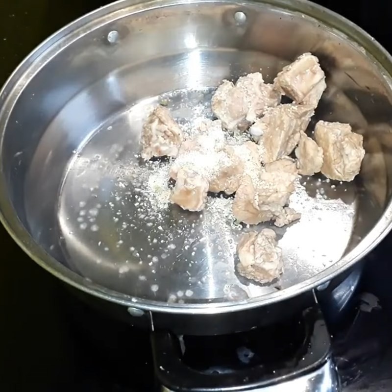 Sườn heo đang được luộc sơ để loại bỏ tạp chất cho món lẩu lòng heo