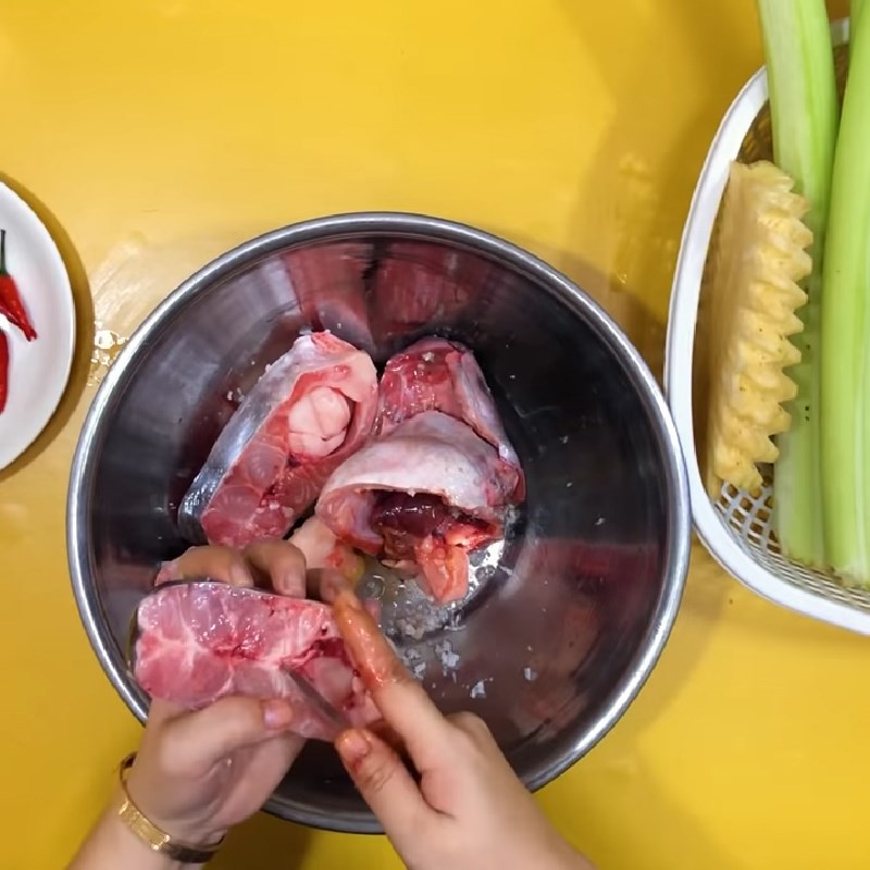 Ướp cá hú với gia vị để chuẩn bị cho món canh chua cá hú