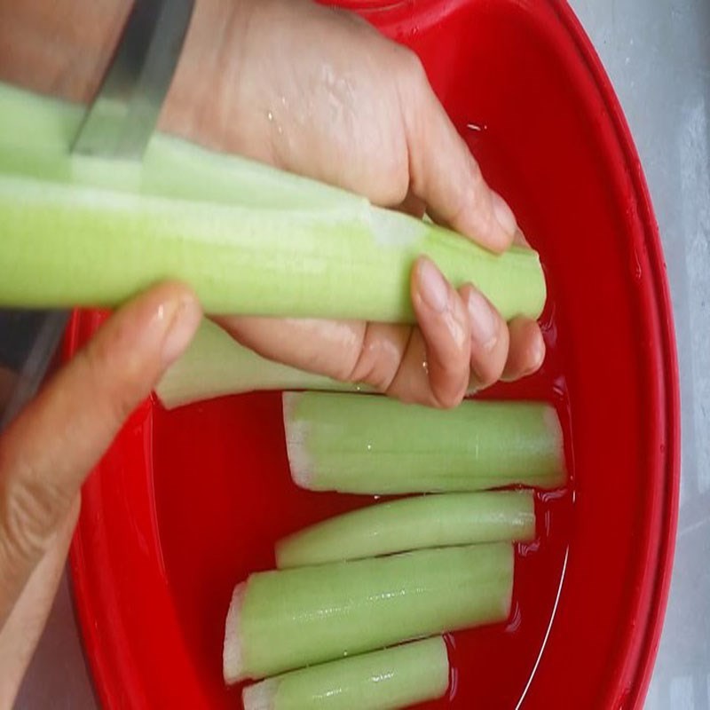 Sơ chế dọc mùng cho món canh hàu mùng, tước vỏ và thái lát cẩn thận