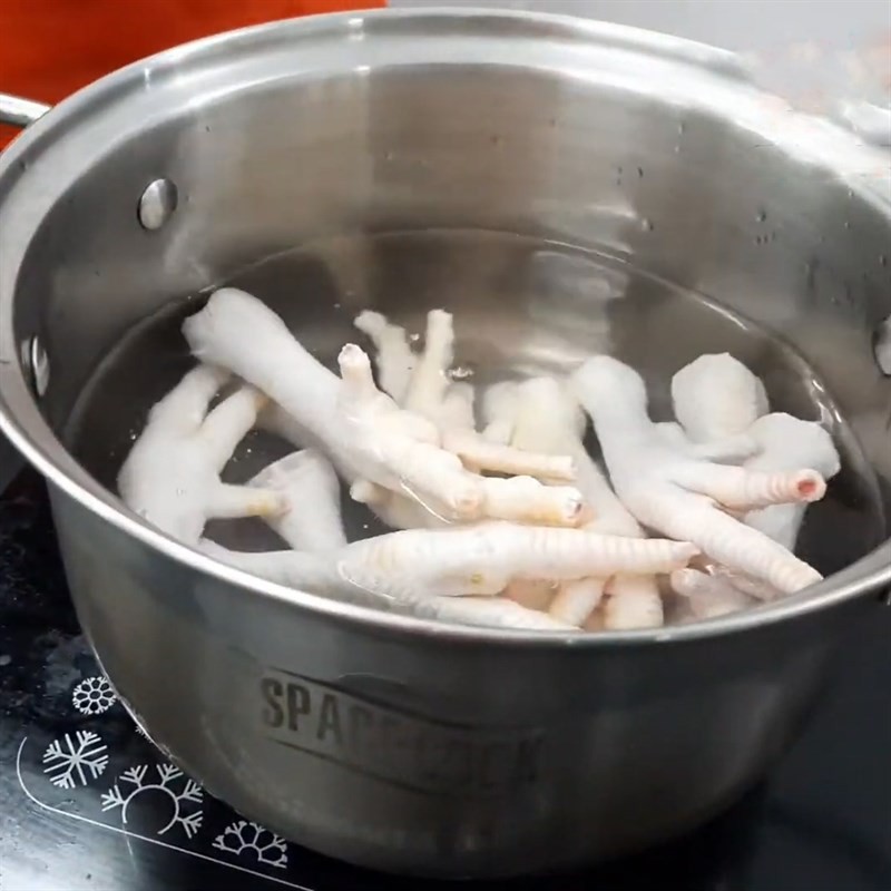 Trụng chân gà qua nước sôi để làm sạch và khử mùi cho nước dùng súp hải sâm