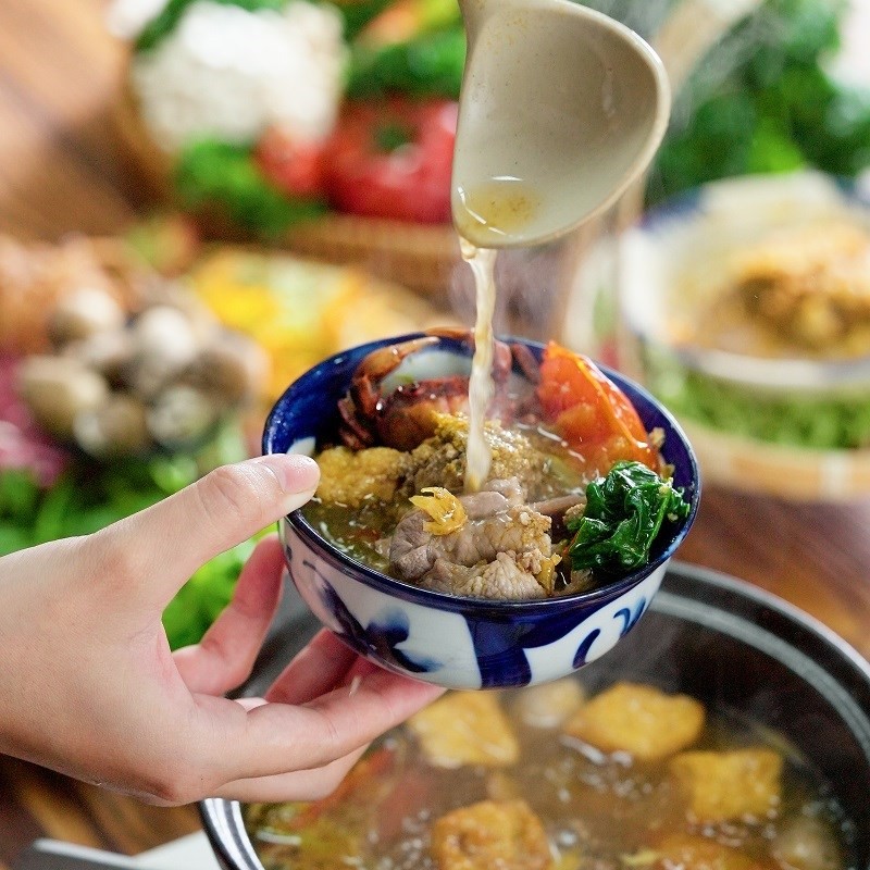 Nồi lẩu riêu cua bắp bò nóng hổi trên bàn ăn
