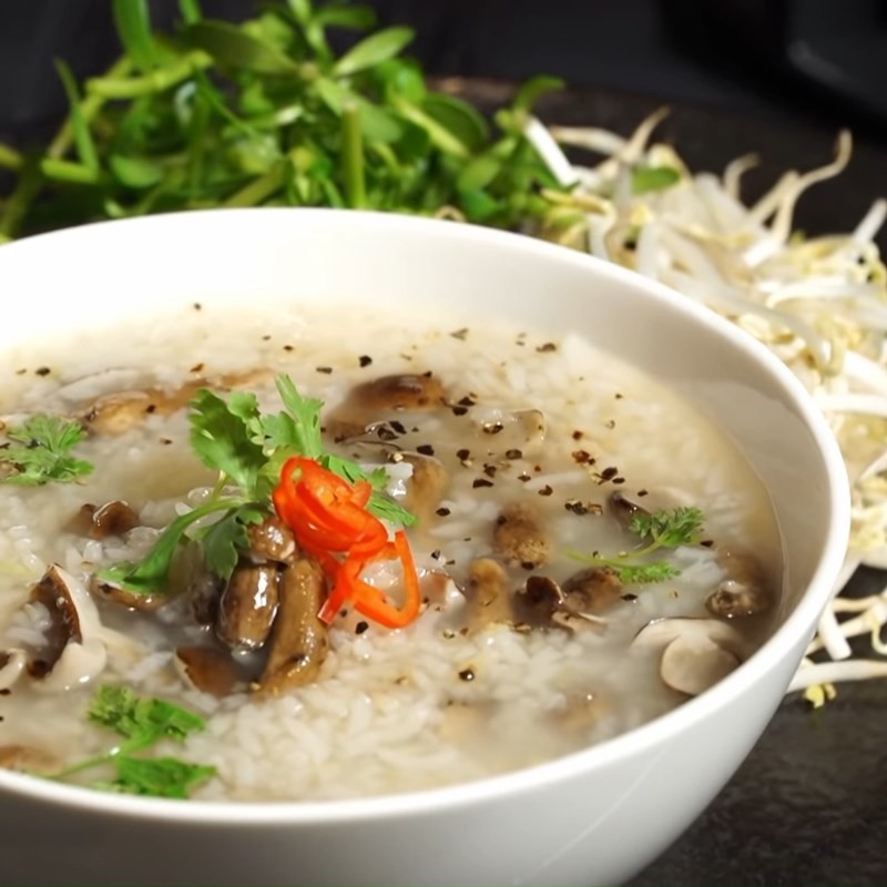 Chén cháo nấm tràm chay ấm nóng, hấp dẫn với tiêu và ngò