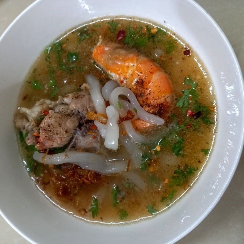 Tô bánh bột lọc xương heo thành phẩm, trang trí hành ngò, sẵn sàng để thưởng thức nóng