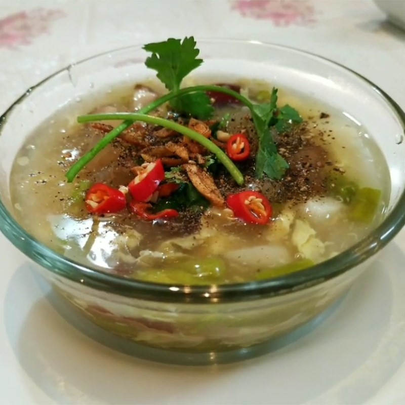 Bát canh kim chi đậu phụ chay hoàn chỉnh, rắc thêm gừng sợi và hành lá tạo hương thơm hấp dẫn.