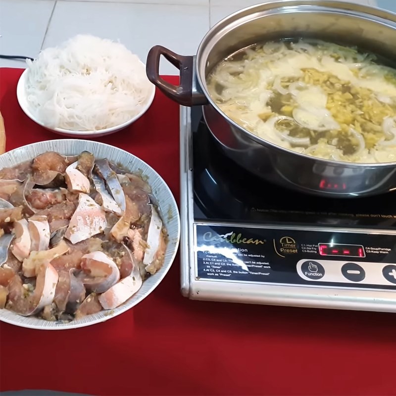 Lẩu cá tra nhúng giấm với rau sống và bánh tráng, nước chấm mắm nêm