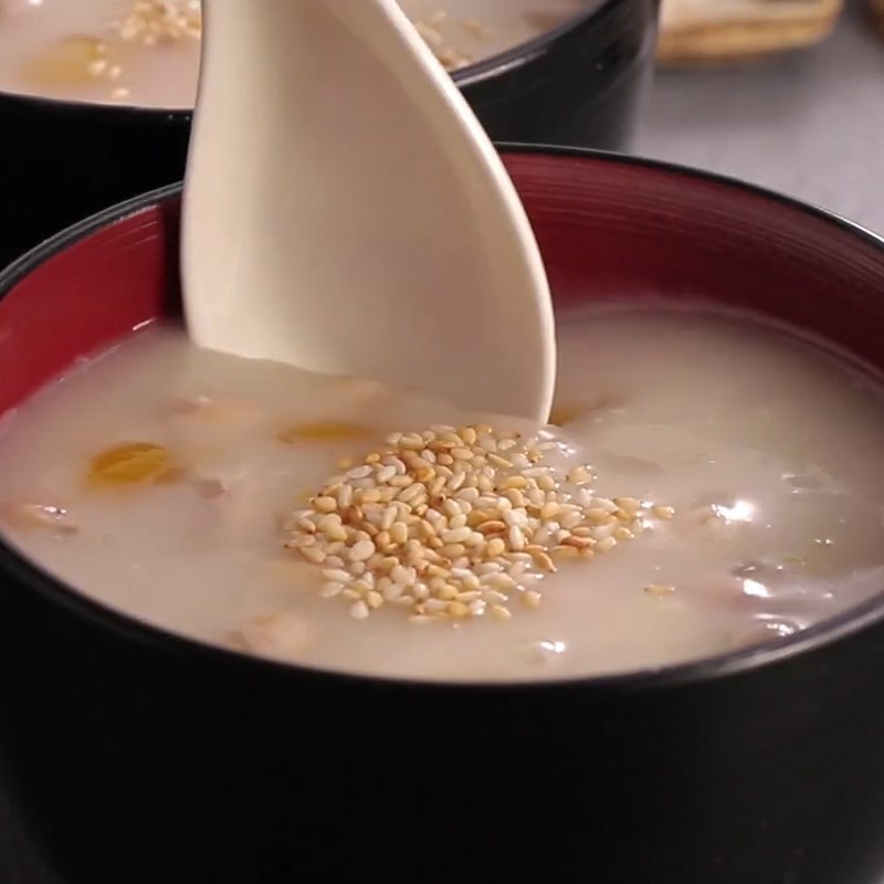 Một chén chè đậu phộng bí đỏ thơm ngon, nóng hổi với màu vàng cam đẹp mắt, rắc thêm mè rang phía trên, sẵn sàng để thưởng thức