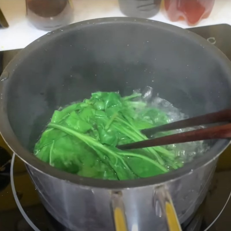 Cải bó xôi xanh mướt đang được trụng qua nước sôi