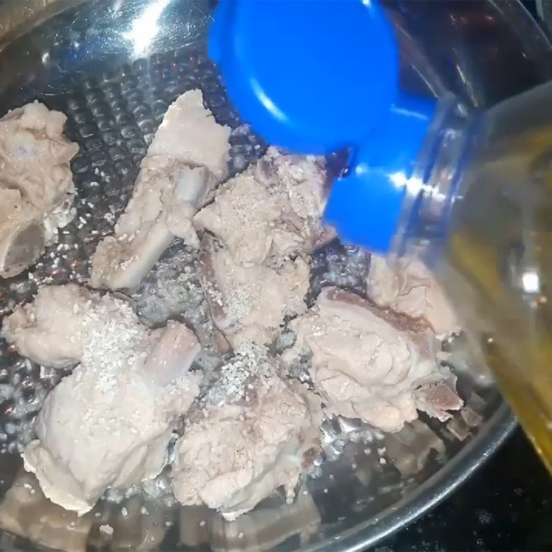 Trộn đều xương heo với gia vị, ướp thấm để nấu canh củ từ ngon hơn