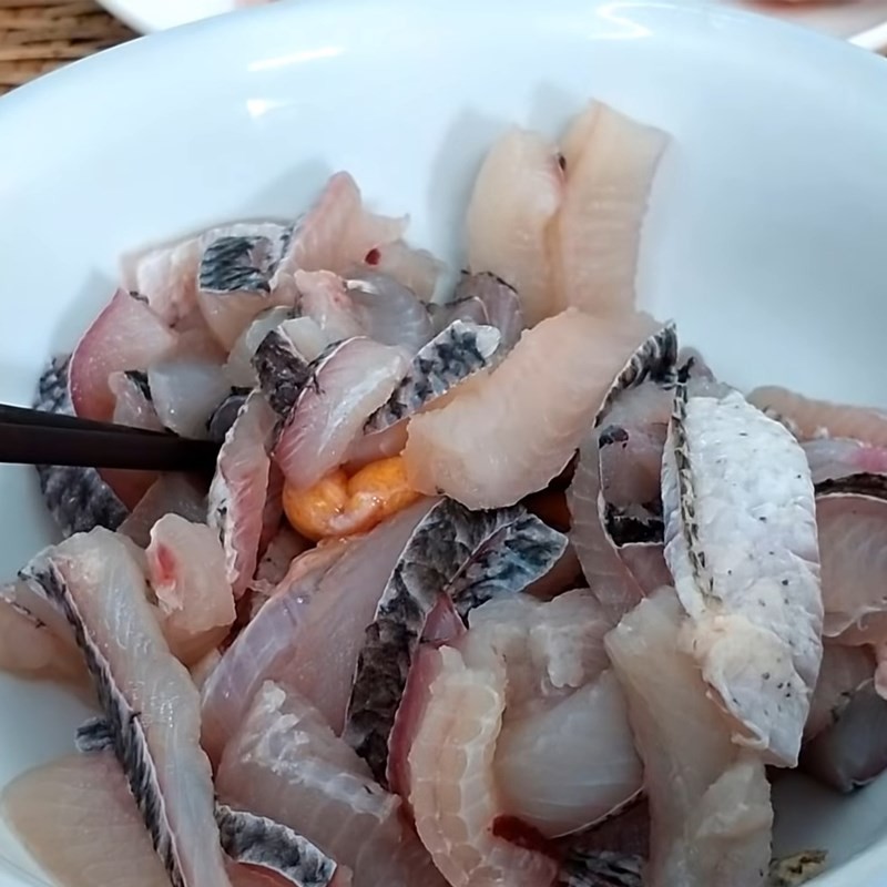Ướp cá lóc với gia vị để chuẩn bị nấu lẩu nấm