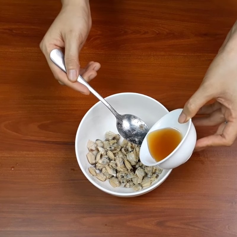 Trộn đều gia vị với thịt nghêu đã tách vỏ trước khi xào