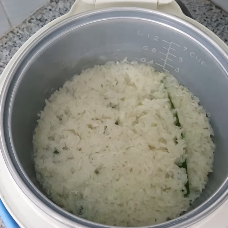 Nồi cơm điện đang nấu gạo nếp, bước quan trọng để làm chè khoai môn