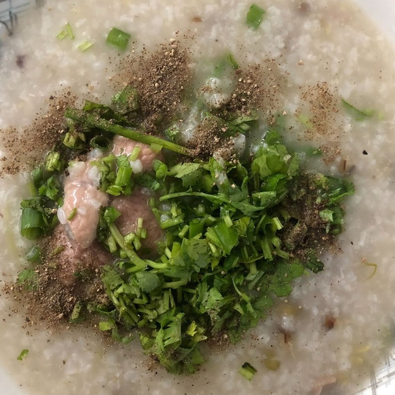 Tô cháo xương heo nóng hổi, thơm lừng đã hoàn thành, sẵn sàng thưởng thức với hành ngò và tiêu
