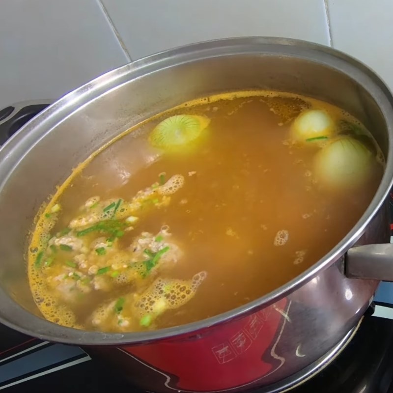 Thịt băm đã ướp được cho vào nồi nước dùng bún thịt cà chua, nấu chín