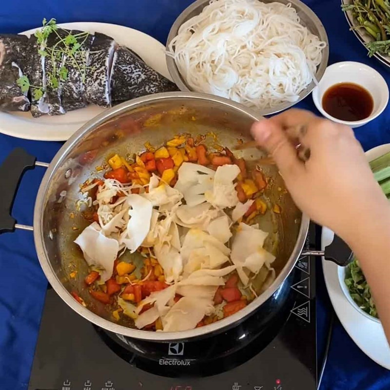 Thêm măng chua vào xào cùng gia vị để lẩu cá mú đậm đà