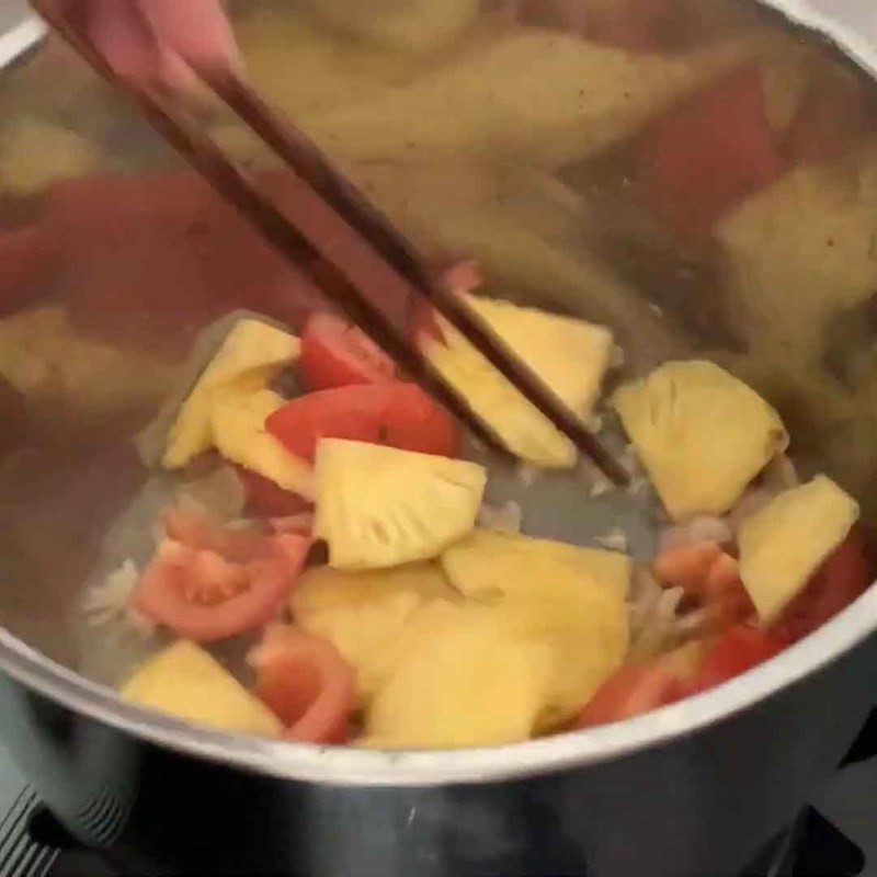 Nêm gia vị vào hỗn hợp xào cho lẩu cá mú chua cay