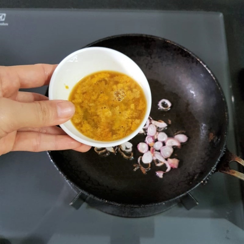 Xào gạch cua với nước mắm, tạo màu sắc và hương vị béo ngậy cho món canh cua chua.