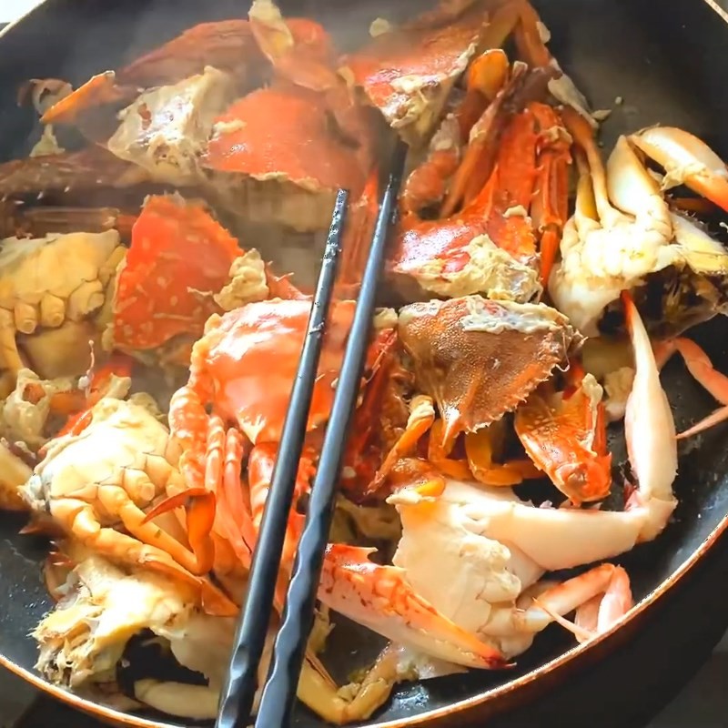 Ghẹ đang được xào trên chảo, chuẩn bị cho công đoạn nấu canh ghẹ rau muống
