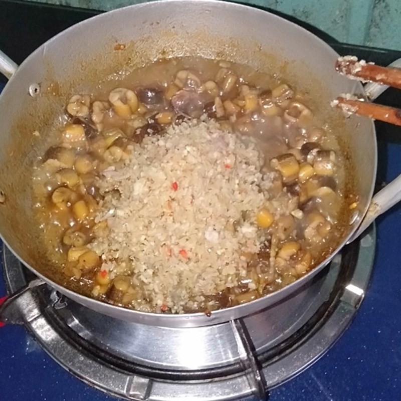 Thêm nước và các loại gia vị sả, ớt vào chảo lươn