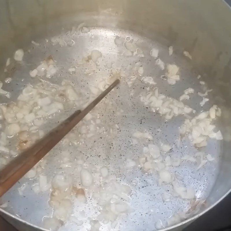 Hành tím phi thơm trên chảo, bước chuẩn bị để xào măng và vịt cho canh