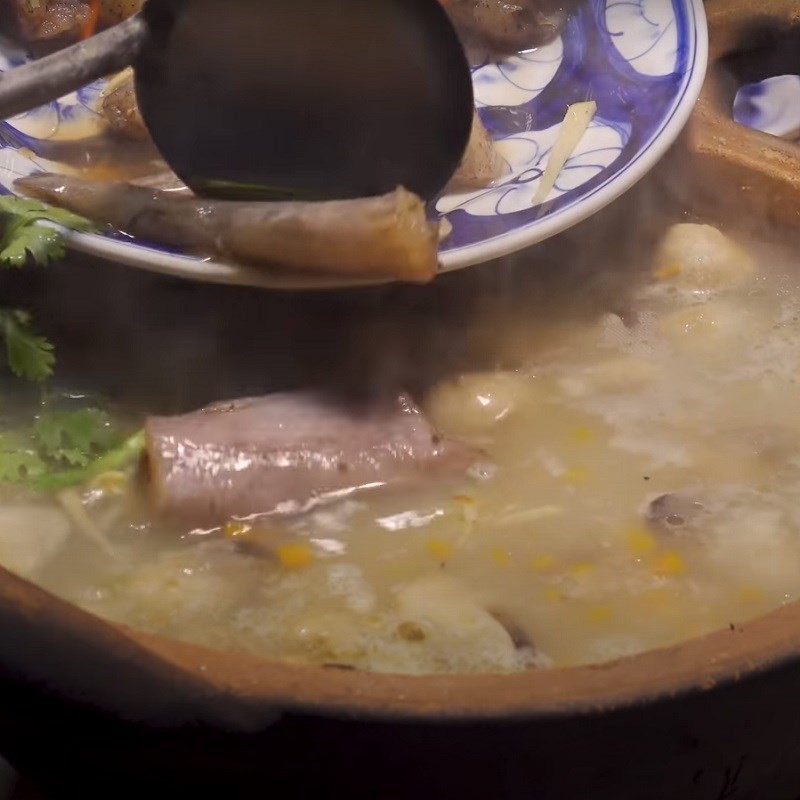 Nồi cháo cá khoai đang sôi nhẹ, gạo nở bung, thơm ngon chuẩn bị hoàn thành