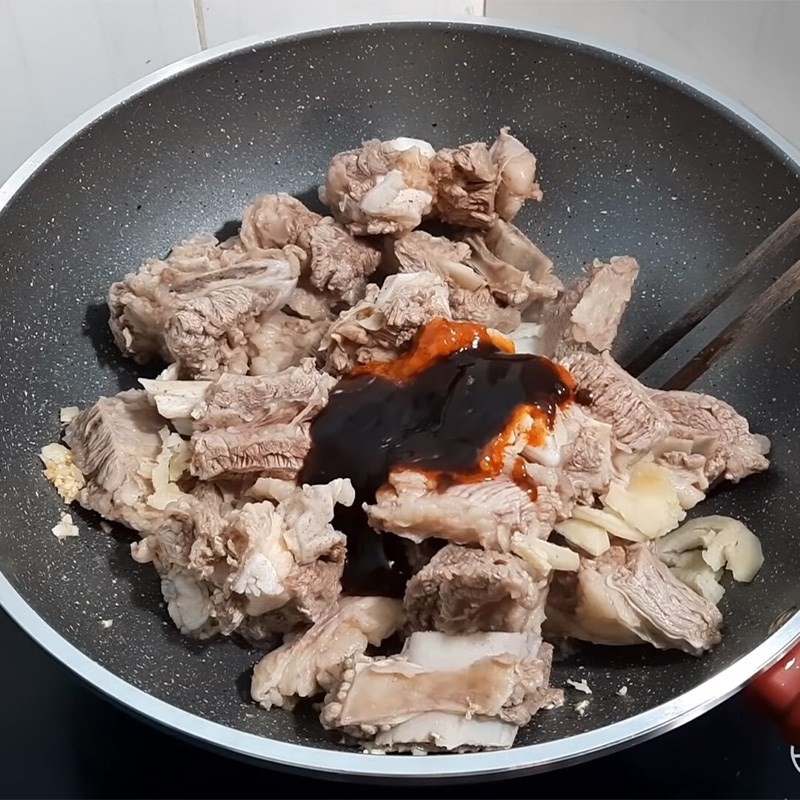 Sườn bò đang được xào thấm gia vị sa tế, tương xay, bước đầu tiên trong quá trình chế biến.