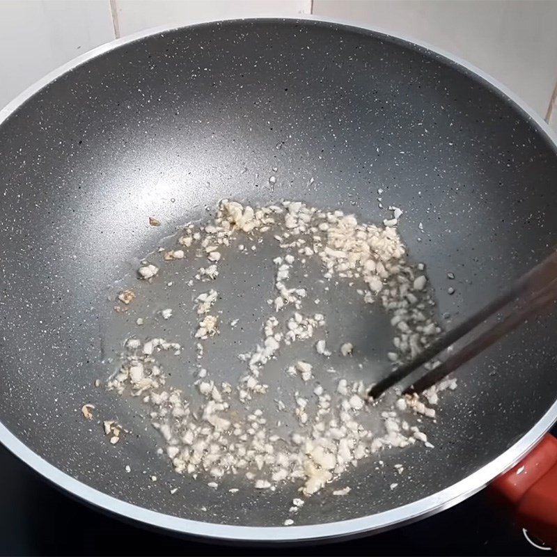 Phi thơm tỏi băm trên chảo nóng để xào sườn bò.
