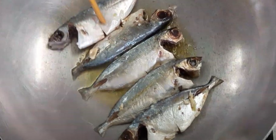 Chiên sơ cá bạc má vàng đều hai mặt trước khi cho vào nồi kho