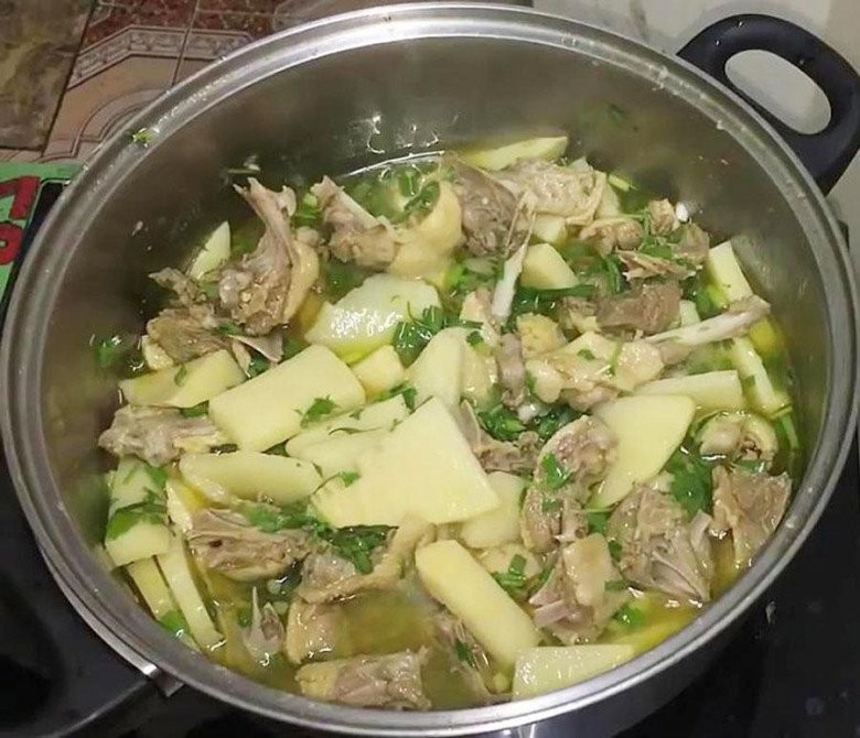 Thêm măng chua vào nồi vịt đang hầm để hương vị hòa quyện