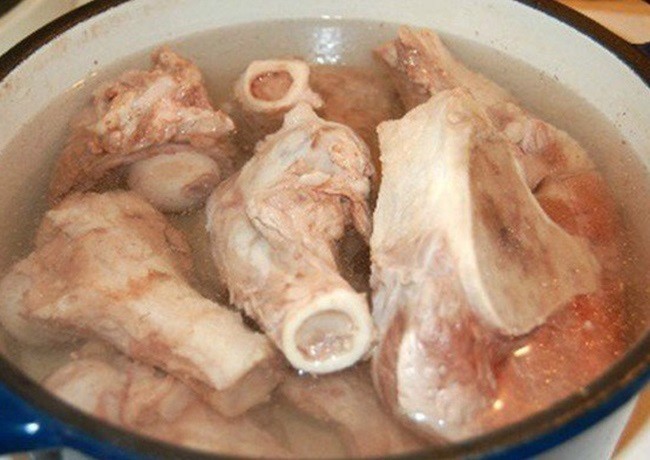 Nồi nước dùng bún cá chấm đang được ninh cùng cà chua, giấm bỗng tạo nên vị chua ngọt thanh đặc trưng, một bí quyết trong cách nấu bún cá đơn giản