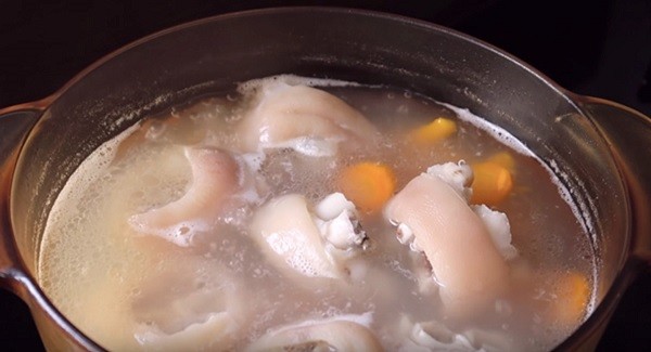 Nồi nước dùng bánh canh giò heo đang ninh xương và cà rốt