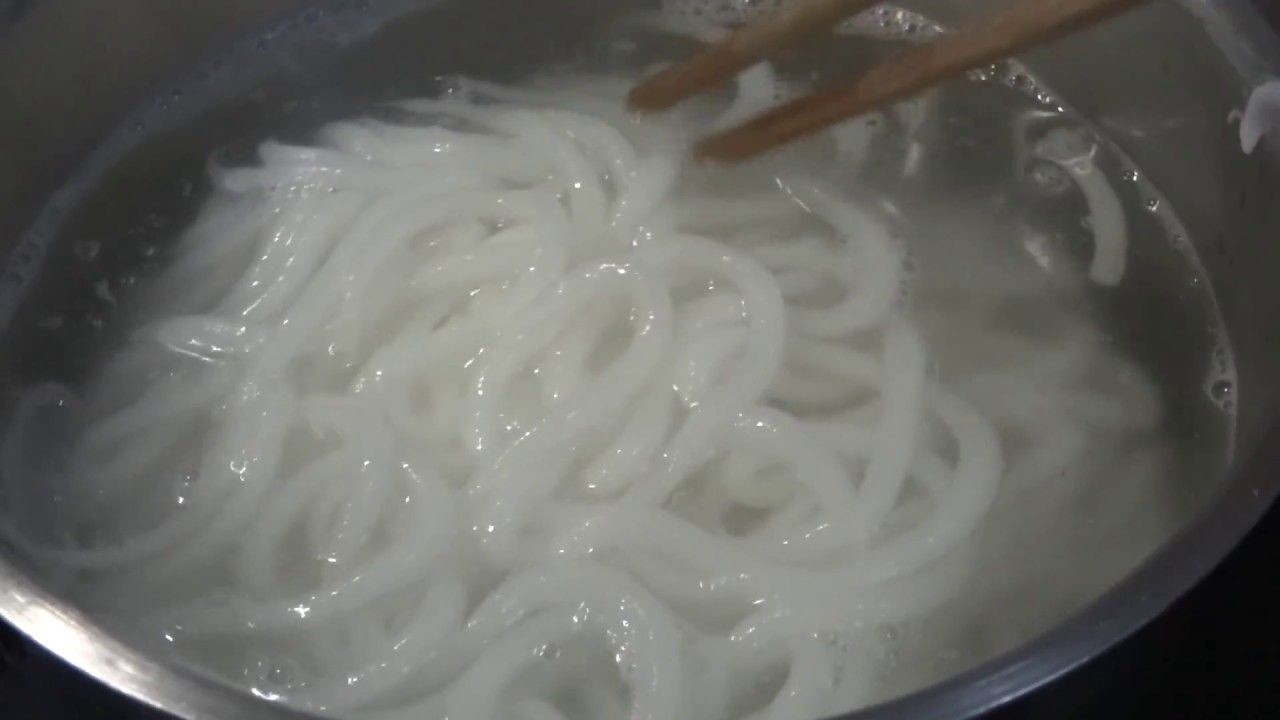 Trụng sợi bánh canh tươi trong nồi nước sôi chuẩn bị cho món giò heo