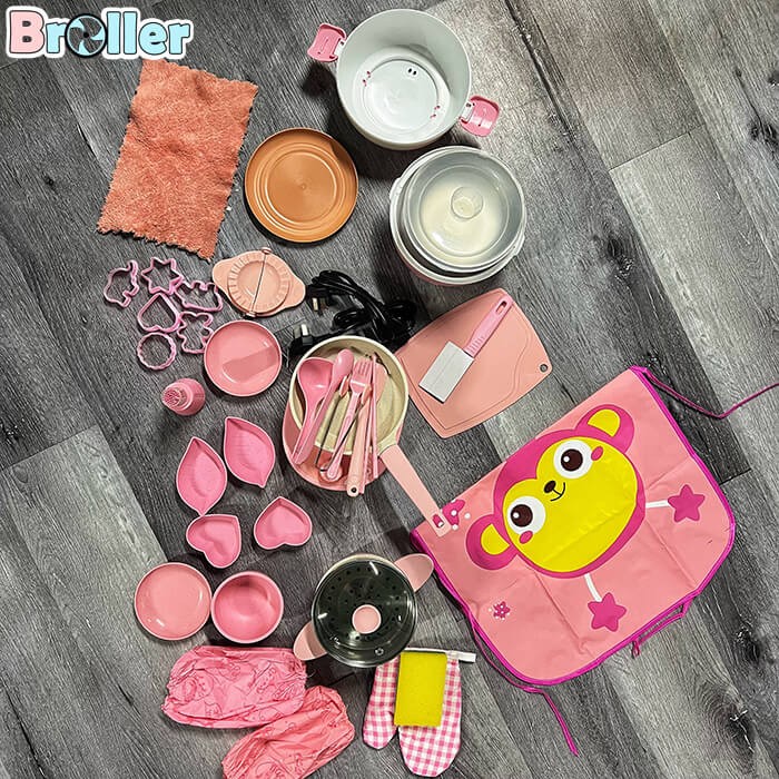 Bé gái đang thực hành cách nấu ăn đồ chơi với bộ dụng cụ nấu bếp 41 món, bao gồm nồi cơm và nồi hấp