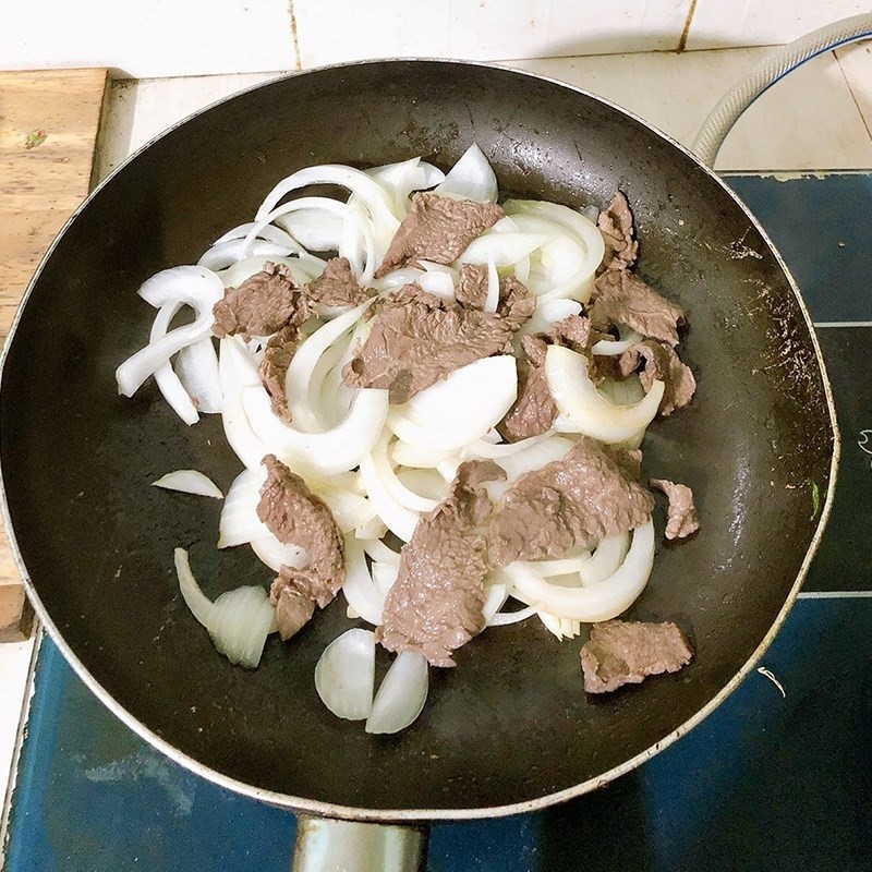 Xào thịt bò đã áp chảo cùng các loại rau củ và gia vị trong nồi lớn