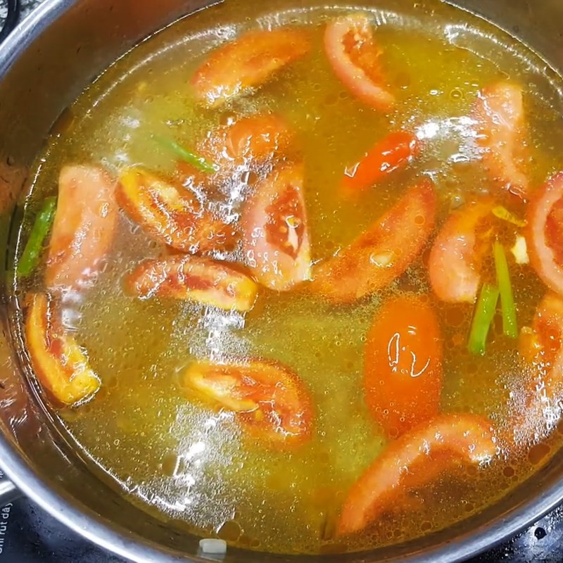 Cho cá chép và trứng cá vào nồi canh chua đang sôi