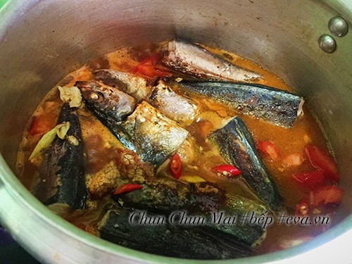 Nồi cá nục đang được kho liu riu cùng sốt cà chua và các gia vị, đảm bảo cá thấm đều hương vị
