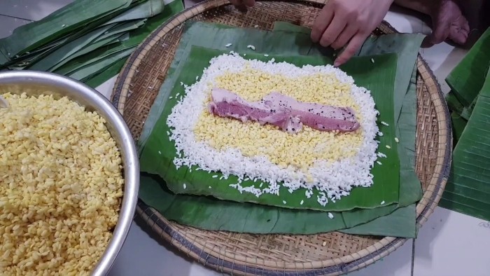 Các lớp nguyên liệu nếp, đậu xanh, thịt ba chỉ được sắp xếp trên lá chuối để gói bánh tét