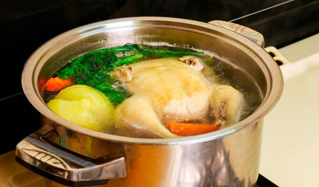 Đặt gà nguyên con vào nồi nước, bước đầu tiên trong cách nấu gà nhanh mềm hiệu quả
