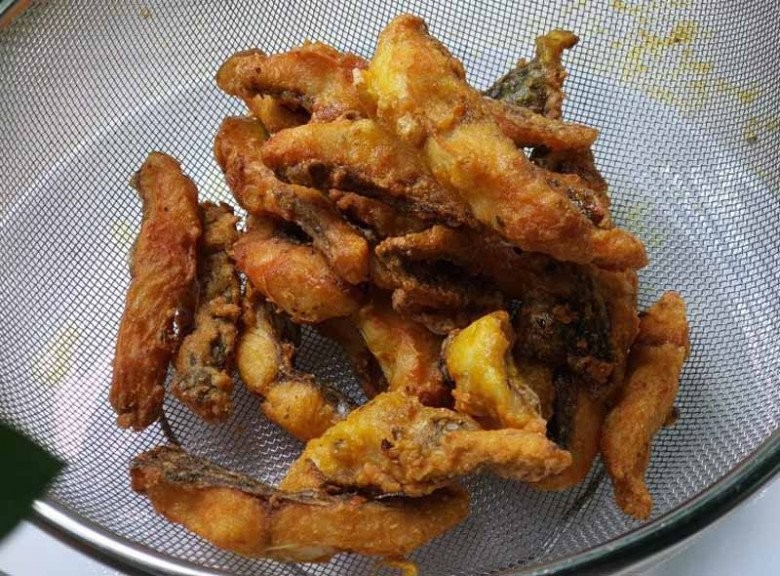 Cá rô phi đang được chiên vàng giòn trong chảo dầu để làm bún cá Hà Nội