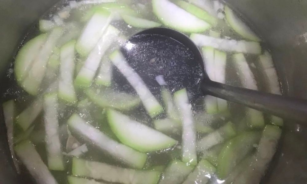 Cách nấu canh bầu ngon: Nồi canh bầu đang sôi trên bếp