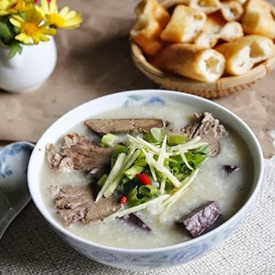 Tô cháo lòng nóng hổi, thơm ngon với hành lá, tiêu và các loại rau ăn kèm
