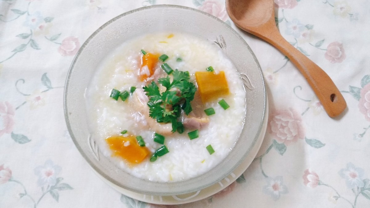 Chén cháo gà bí đỏ thơm ngon, nóng hổi, trang trí đẹp mắt với hành ngò và tiêu xay, sẵn sàng thưởng thức.