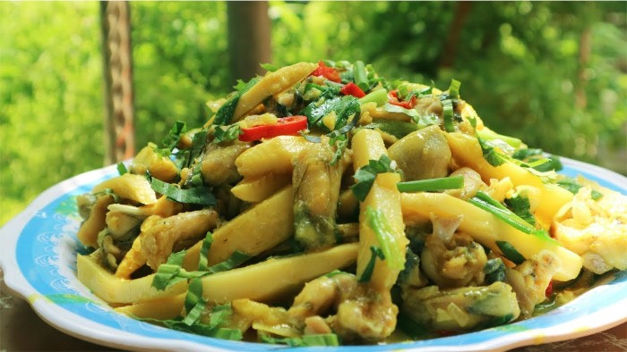Đĩa ếch xào măng chua nóng hổi, thịt ếch vàng ươm, măng chua giòn, được trang trí bằng hành lá và ớt, sẵn sàng để thưởng thức.