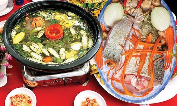 Một nồi lẩu cá vược nóng hổi với thịt cá tươi, rau xanh và nước dùng chua cay đậm đà, sẵn sàng để thưởng thức.