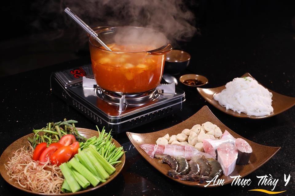 Bữa lẩu chua cay nóng hổi với đầy đủ các loại topping và rau ăn kèm, sẵn sàng cho mọi người thưởng thức