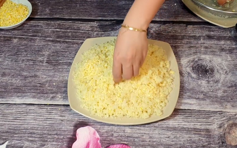 Rắc đậu xanh giã nhuyễn và trộn đều vào xôi sau khi đồ để tăng hương vị và độ bùi cho món xôi chè