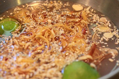 Xào khế và cà chua là bước quan trọng tạo vị chua thanh và màu sắc hấp dẫn cho nước lẩu cá vược.