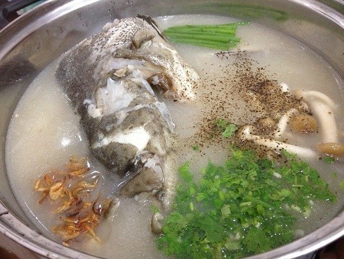 Món cháo cá mú thơm ngon đậm đà với rau thơm, gừng thái sợi, là một cách nấu cá mú ngon miệng